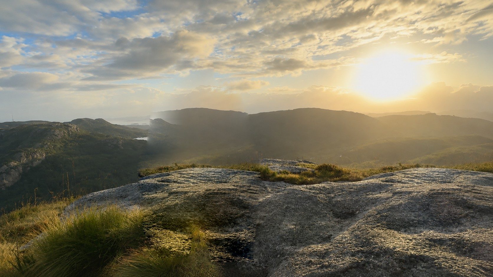 Sunrise over mountain ridges, seen from a granite summit